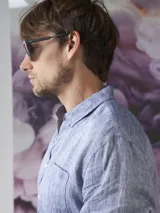 Camisa azul de lino con botones blancos, manga larga y bolsillo en el pecho.
