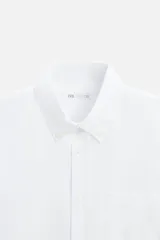 Camisa azul marino de corte regular fit, confeccionada en tejido de algodón Oxford. Tiene cuello abotonado, manga larga con puños abotonados, bolsillo de parche en el pecho y cierre frontal con botones.