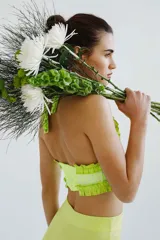 Top de escote halter color verde flúor, confeccionado en broderie de algodón y bordado con hilo color flúor. Enmarcado con voladitos de lino a tono.