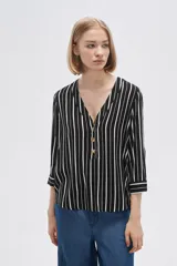 Camisa holgada de viscosa con estampado de rayas verticales en blanco y negro, cuello en V y mangas 3/4 con detalle de botones.