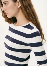 Remera de punto color crema con rayas horizontales negras, de mangas largas y cuello redondo.