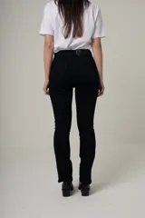 Jean negro de tiro alto, corte recto slim, con diseño clásico de cinco bolsillos y cierre frontal con botón metálico.