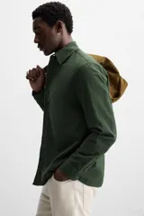 Camisa azul marino de algodón con textura jacquard, corte relaxed fit, cuello solapa, manga larga con puños abotonados y cierre frontal con botones.