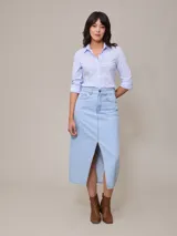 Falda midi de jean celeste con corte delantero y bolsillos.