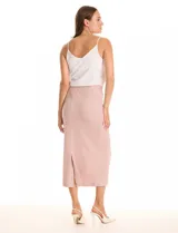 Falda midi color rosado, de la marca Zac & Rachel, con pretina ancha elastizada y tejido con lurex. Presenta un corte vertical en la parte trasera.