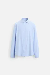 Camisa celeste a rayas verticales blancas, de corte recto, con cuello italiano, manga larga y cierre frontal con botones.