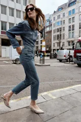 Pantalón de jean azul de tiro alto, corte mom fit, tobillero y con cinco bolsillos. Cierre frontal con cremallera y botón.