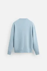 Jersey celeste de cashmere y lana, de corte relajado, cuello redondo y manga larga con terminaciones en rib.