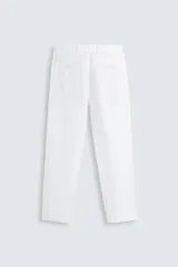 Pantalón de vestir blanco, confeccionado en lino, de corte recto, con bolsillos laterales y traseros. Se ajusta a la cintura con botón y cierre.