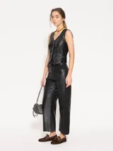 Pantalón de cuero vacuno negro con laterales en gabardina al tono. El acceso es mediante cierre metálico y botón jeanero. Incluye bolsillos estilo jeanero al frente y bolsillos plaque en la parte trasera.