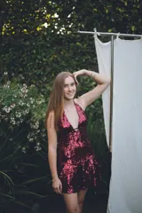 Vestido corto con lentejuelas color verde esmeralda, escote en V profundo y espalda descubierta.