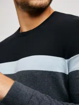 Sweater de punto verde oscuro con franjas horizontales blancas y verde esmeralda. De corte clásico y escote redondo.