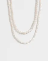 Set de dos collares de perlas blancas de diferentes largos.