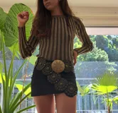 Buzo marrón con rayas verticales doradas, de corte ajustado y mangas largas.