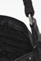 Cartera tipo hobo de cuero vacuno color negro, con apliques de tachas doradas y plateadas. Tiene un asa corta trenzada y dos bolsillos externos con cierre.