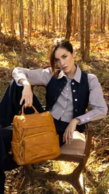 Mochila color beige de símil cuero con apertura superior y dos bolsillos frontales con cierre metálico. Incluye bolsillos laterales, tres bolsillos internos, correa larga regulable y correas traseras regulables.