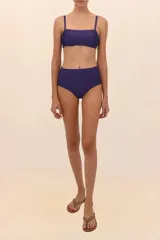 Top de bikini estilo bandeau con escote cuadrado y tirantes delgados. Presenta frunces a los costados que realzan el busto.