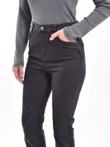 Pantalón de jean color borgoña, de corte ajustado con aberturas en el ruedo.