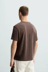 Camiseta marrón de punto, corte regular, cuello redondo y manga corta con terminaciones en rib.