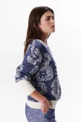 Sweater azul con estampado de flores blancas y puños blancos.
