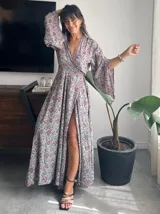Kimono largo de seda con estampado floral en tonos verde, marrón y beige. Tiene mangas amplias y corte cruzado con lazo ajustable en la cintura.
