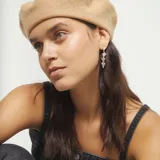 Pendientes largos plateados, tipo colgante, compuestos por tres corazones tridimensionales apilados por par.