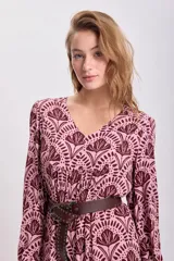 Vestido largo de corte holgado con estampado floral en tonos rosa y marrón. Tiene escote en V, mangas largas abullonadas y cinturón marrón de cuero sintético.