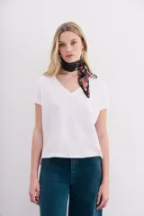 Remera blanca de algodón peruano, de corte ajustado y escote en V pronunciado.