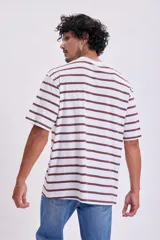 Remera de algodón con rayas en colores blanco y marrón, de corte amplio y manga corta.