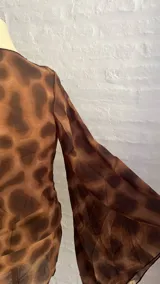 Minivestido marrón con estampado animal print, escote drapeado pronunciado y mangas largas acampanadas.