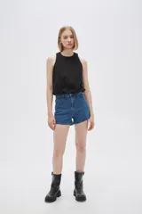 Blusa blanca de algodón sin mangas, con cuello a la base, abertura en la espalda y lazo ajustable.