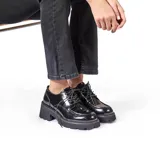 Zapato estilo oxford de charol negro, con cordones y plataforma gruesa de goma con relieve.