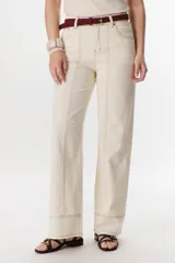 Pantalón negro de corte recto, pierna ancha y tiro alto, con detalles de pespuntes blancos a contratono.