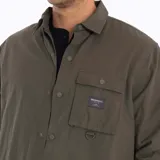 Sobrecamisa Merrell color verde oliva, confeccionada en algodón suave y resistente. Cuenta con cuello clásico, cierre frontal con botones a presión, bolsillo de parche en el pecho izquierdo con etiqueta de la marca y puños con botón.