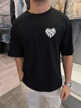 Remera negra de algodón con corte oversize y estampado de un corazón roto con diseño de cebra y la frase "very good" en la espalda.