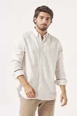 Camisa de lino color blanco, de corte regular, con cuello clásico y mangas largas.