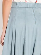 Pollera midi celeste de poliéster y elastano con vuelo y cinturón elastizado con hebilla.