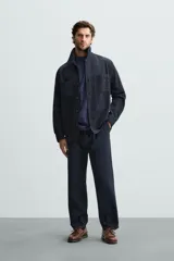 Pantalón azul marino de corte recto, confeccionado en tejido de algodón y lino. Tiene cintura elástica ajustable con cordón, bolsillos delanteros y traseros de vivo.