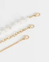 Set de tres chokers dorados, uno de cadena snake, otro de cadena de bolitas y un tercero de perlas.