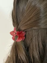 Pinza para el pelo color rojo con forma de flor.