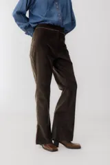 Pantalón de pana marrón con corte acampanado y abertura en el ruedo.