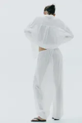 Pantalón bombacho de algodón blanco, con tiro medio, cintura elástica ajustable con cordones y bajo abullonado con elástico.