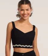 Blusa cropped negra de lino y algodón, con escote corazón, breteles anchos y detalle de bordado ondulado en el ruedo.