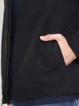 Campera negra con cuello camisero, cierre frontal con cremallera, dos bolsillos laterales y logo de Tommy Hilfiger bordado en el pecho.