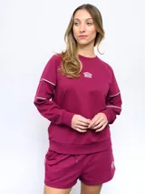 Buzo de felpa color borgoña con cuello redondo y logo de la marca bordado en el pecho. Presenta detalles de ribete blanco en los hombros y puños.