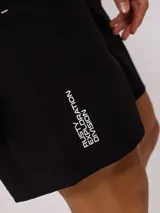 Short de baño negro con logo de la marca Rusty estampado en blanco en la pierna derecha.