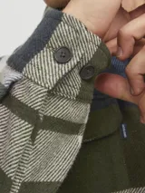 Sobrecamisa de manga larga a cuadros en tonos verde, azul y blanco. Tiene cuello clásico, cierre con botones, dos bolsillos en el pecho con botón y corte relajado.