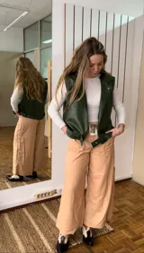 Chaleco verde de ecocuero con cuello solapa y cierre con botones a presión.