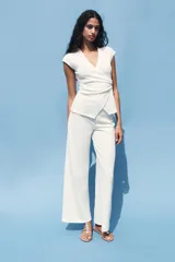 Pantalón de tiro medio color marrón claro, con cintura elástica y tejido con textura.
