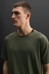 Camiseta deportiva color verde oliva de tejido ligero y elástico, con cuello redondo, manga corta y logo estampado en el bajo. Zara Athleticz.